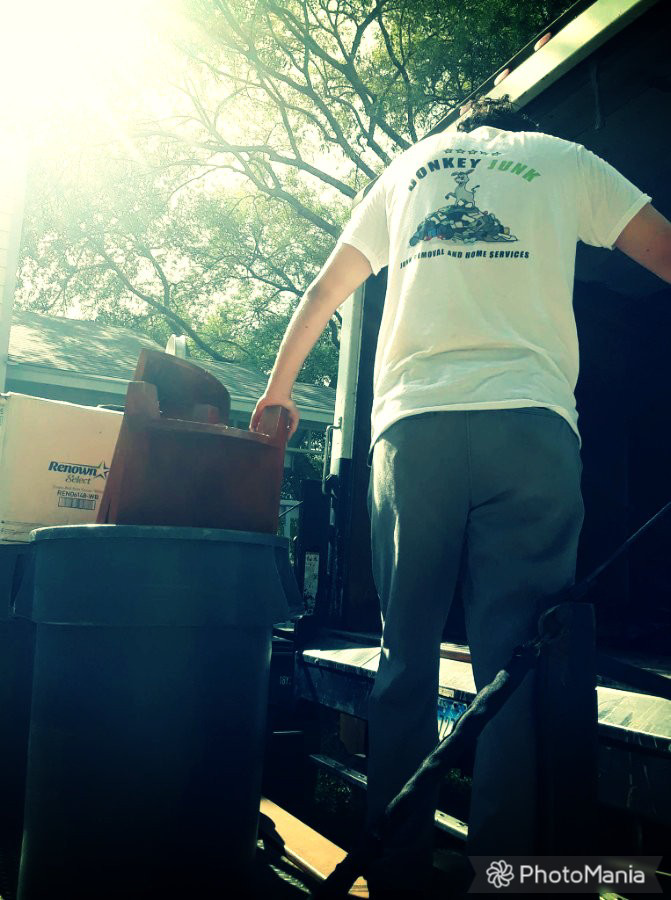 A DonkeyJunk Removal and Home Services worker loading items onto a junk removal truck in Austin, TX