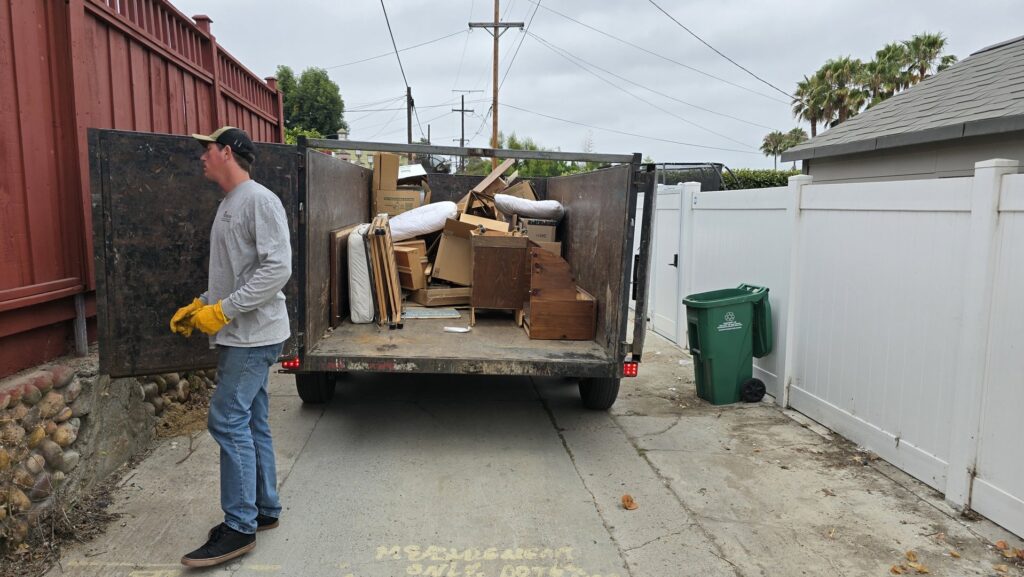 A worker loading a trailer full of boxes and debris for 24/7 Junk Removal in Rolling Hills Estates, CA.