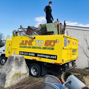 A Junk to Go worker loading furniture and boxes onto a junk removal truck during a job in Philadelphia, PA.