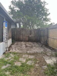 A worker removing a pile of wooden pallets and construction debris for Junk Fade Away, LLC in Jacksonville, FL.