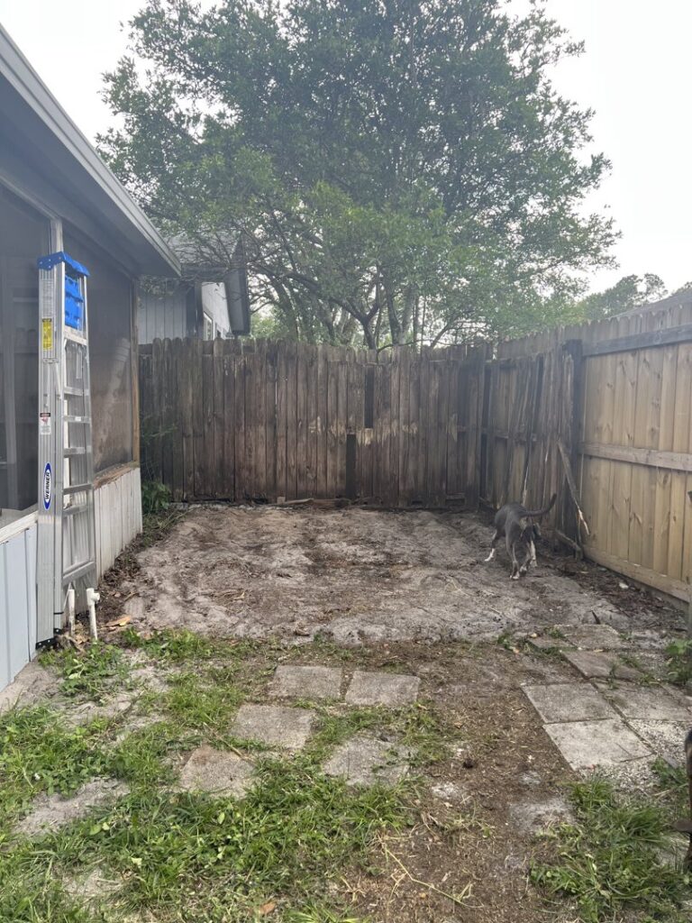 A worker removing a pile of wooden pallets and construction debris for Junk Fade Away, LLC in Jacksonville, FL.