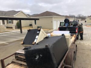 Workers loading sofas and mattresses onto a trailer for a junk removal job by Perez Junk Removal in Anaheim, CA.