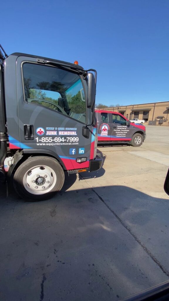 SQS Junk Removal workers loading household junk and furniture into a large dumpster during a cleanup in Charlotte, NC.