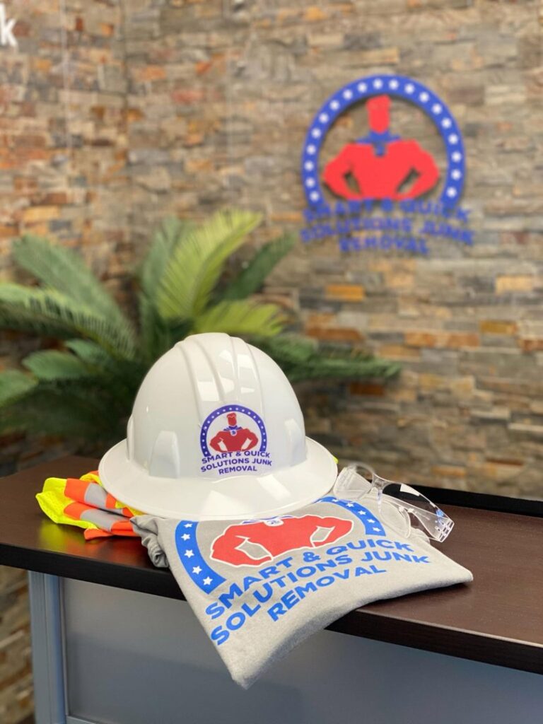 Two SQS Junk Removal workers moving wood debris from a residential property in Charlotte, NC.